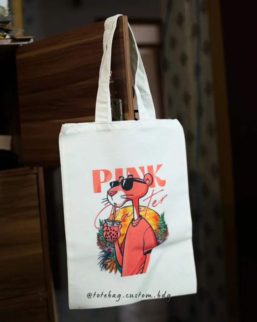 Totebag blacu custom ukuran 25x35 cm dengan desain karakter Pink Panther bergaya santai memakai kacamata dan minum boba, cocok untuk anak muda dan pecinta desain unik di Bandung